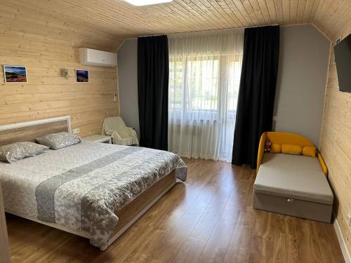 a bedroom with a bed and a window at Carpathian Dream Apartments in Yaremche