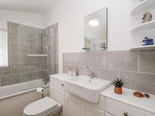 a white bathroom with a sink and a toilet at Wharf Cottage in Lechlade