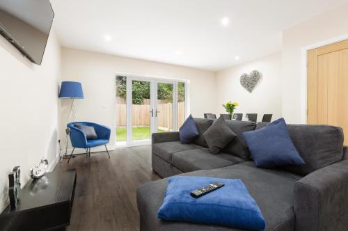 a living room with a gray couch and blue pillows at Norris - Parking Wi-Fi Contractors in Preston