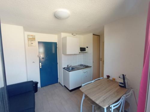 Ce petit appartement comprend une table et une cuisine. dans l'établissement Les logis de Paray - Appt 408 - Plein Centre-Ville de Paray-le-Monial, à Paray-le-Monial