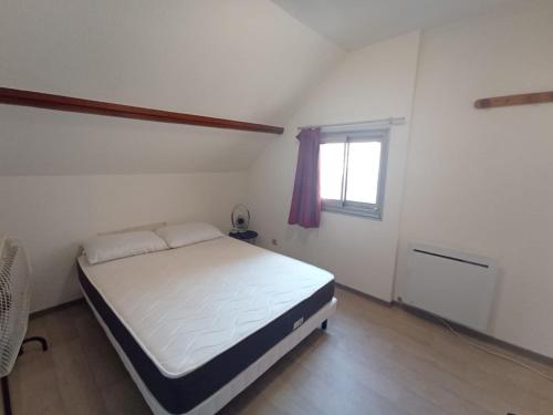 - une chambre blanche avec un lit et une fenêtre dans l'établissement Les logis de Paray - Appt 408 - Plein Centre-Ville de Paray-le-Monial, à Paray-le-Monial