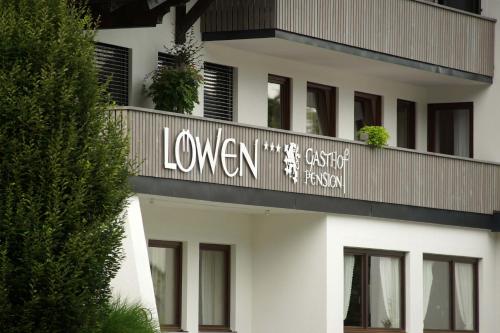 a white building with a sign on it at Pension Löwen in Andelsbuch