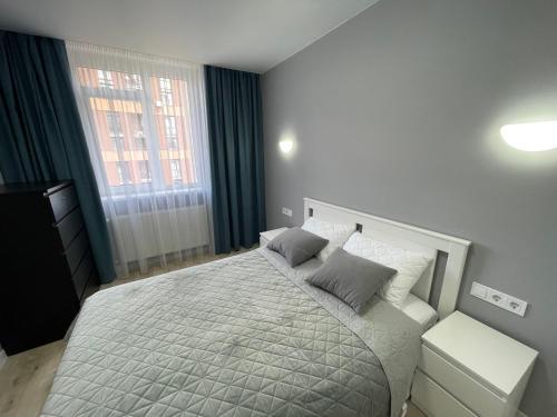 a bedroom with a white bed with two pillows at Апартаменти в новобудові Авалон Зелена in Lviv
