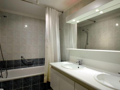 ein Badezimmer mit einem Waschbecken, einer Badewanne und einem Spiegel in der Unterkunft Celine 0201 apartment in De Haan in De Haan