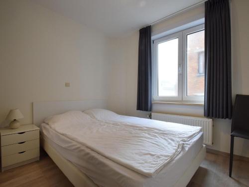 ein Schlafzimmer mit einem weißen Bett und einem Fenster in der Unterkunft Celine 0201 apartment in De Haan in De Haan