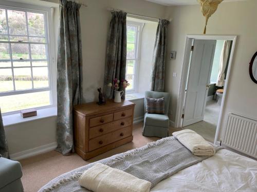 a bedroom with a bed and a dresser and a window at Stone House in Kington