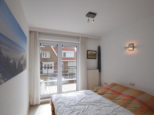 1 dormitorio con cama y ventana grande en Cockpit 0102 apartment overlooking the sea, en De Haan