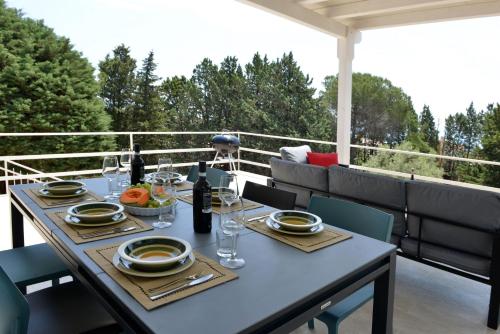 una mesa con platos y copas de vino en un patio en Villa Pica by PosarelliVillas, en San Corrado di Fuori