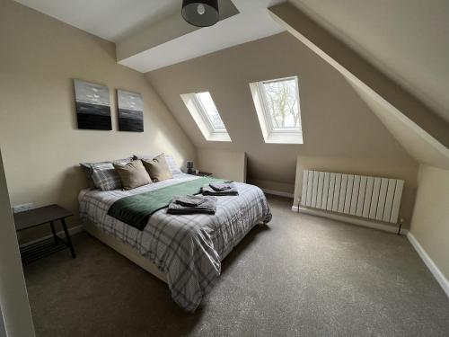 ein Schlafzimmer mit einem Bett und zwei Fenstern in der Unterkunft Charming 4-Bed House in Winchester Free Parking in Winchester