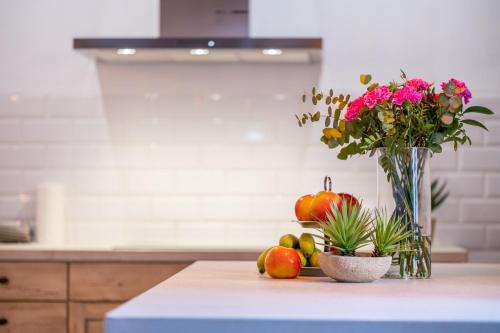 a table with a vase of flowers and fruit on it at S'alqueria in Sóller