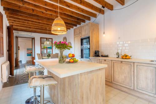 a kitchen with wooden cabinets and a island with fruits on it at S'alqueria in Sóller