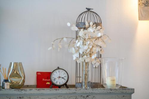 a shelf with a bird cage and a clock on it at S'alqueria in Sóller