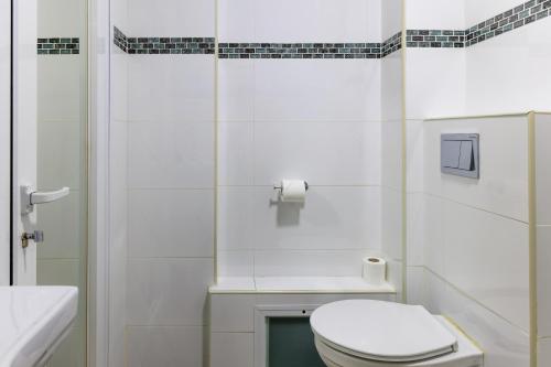 a white bathroom with a toilet and a sink at Domus Bat Galim Hotel in Haifa