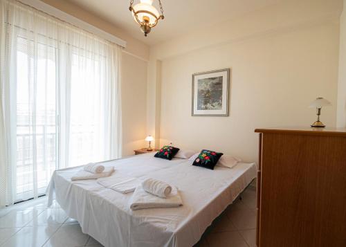 a bedroom with a white bed with towels on it at Anastasia Sea View by RentalsPro Services - Nea Potidaia Halkidki in Nea Potidaea
