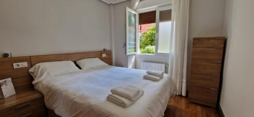 een slaapkamer met een bed met twee handdoeken erop bij Family Apartment / Apartamento familiar Getxo in Getxo
