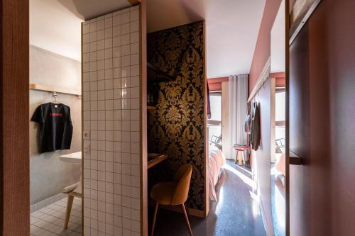Baño pequeño con vestidor y silla en MOB HOTEL Lyon Confluence, en Lyon