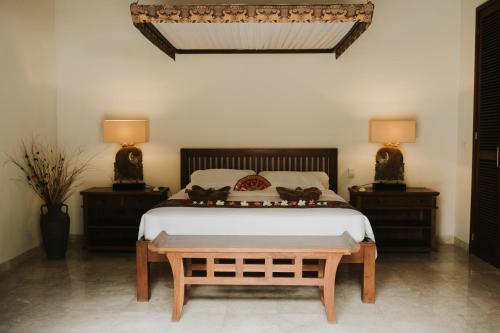 a bedroom with a large bed with two night stands at ALOKA BAHARI Villas in Tejakula