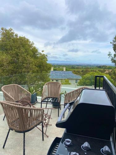 a patio with two chairs and a ping pong table at Constantia View Apartments- Luxury Self Catering in Cape Town