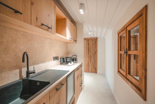 a kitchen with wooden cabinets and a sink at 6 ROOMS BY AZUMARE in Side