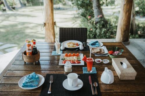 a table with plates of food on top of it at ALOKA BAHARI Villas in Tejakula