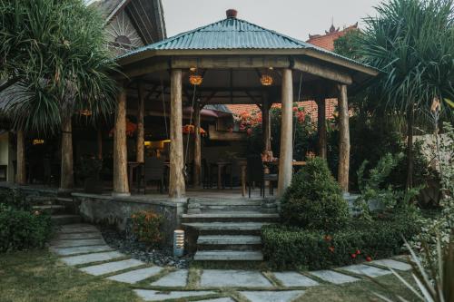 a gazebo with a table and chairs in a garden at ALOKA BAHARI Villas in Tejakula