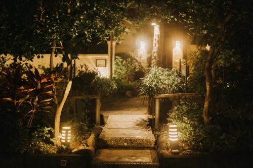 a garden lit up at night with lights at ALOKA BAHARI Villas in Tejakula