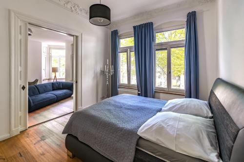 a bedroom with a bed and a couch and windows at Modern 6 bathroom villa in the city in Oldenburg