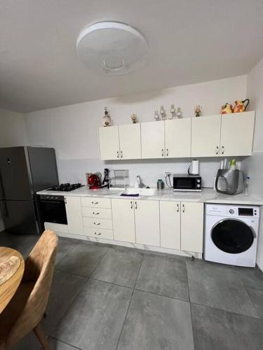 a kitchen with white cabinets and a black refrigerator at Galilee sea Sunset Suites in Migdal