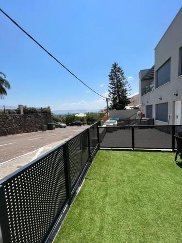 a balcony with green grass on a building at Galilee sea Sunset Suites in Migdal