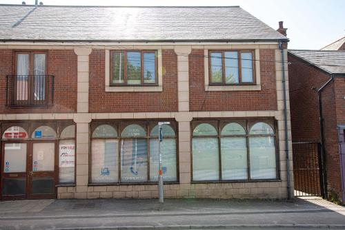 a brick building with many windows on a street at Eagle homely apartment in Kettering