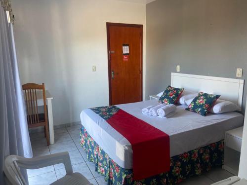 a bedroom with a bed and a wooden door at Teuthos Hotel in Teutônia