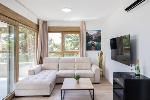 a living room with a white couch and a table at Salt&Soul Residence in Povljana
