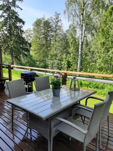 une table et des chaises sur une terrasse avec un grill dans l'établissement Kiurun Villas, à Imatra