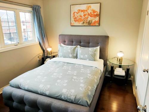 sypialnia z dużym łóżkiem z dwoma stołami w obiekcie Affordable Room with FREE Parking in Newmarket ON w mieście Newmarket