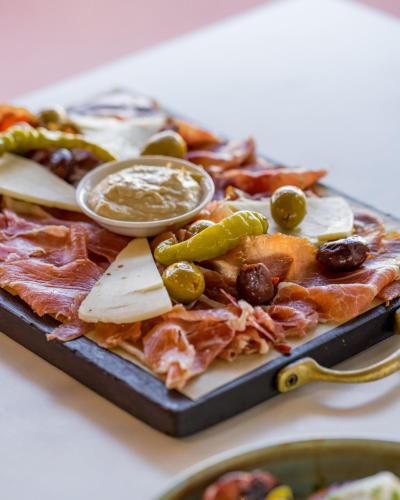 a pizza with cheese and vegetables on a table at The Beaconsfield Hotel in Fremantle
