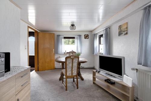a living room with a table and a television at An der Rehkoppel in Boren