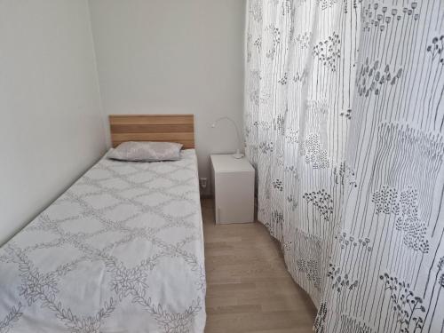 a small bedroom with a bed and a wall at Beautiful Modern City Apartment in Kuopio