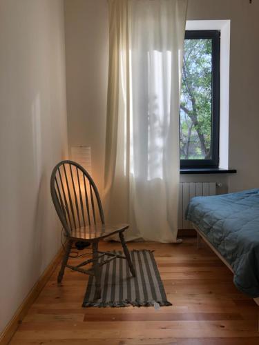 a chair in a room with a bed and a window at Cozy house in Gyumri