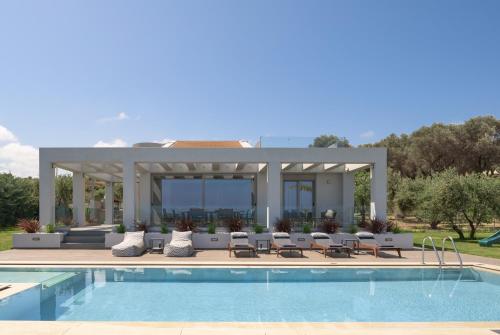 a villa with a swimming pool and a patio at Agrielia Villas, featuring Heated Spa Whirlpool, By ThinkVilla in Pigianos Kampos