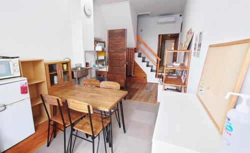 a kitchen and dining room with a table and chairs at ゲストハウス 編湊 in Nakaminato