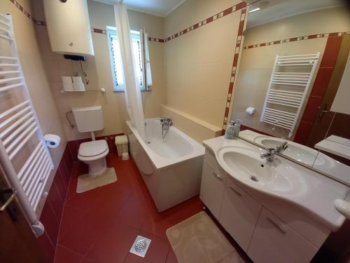 ein Badezimmer mit einem Waschbecken, einem WC und einer Badewanne in der Unterkunft Apartmani Dijana in Rab
