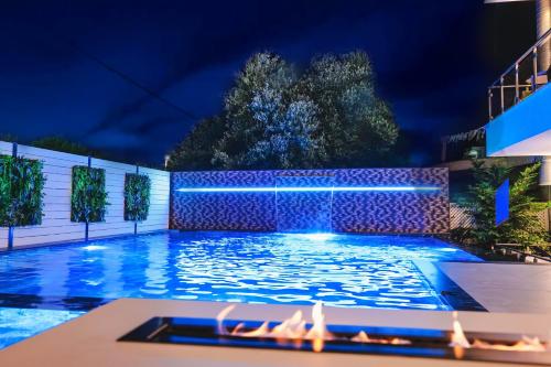 a swimming pool at night with a fountain at Hotel Mare in Ksamil
