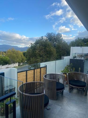 three chairs sitting on a balcony with a view at Constantia View Apartments- Luxury Self Catering in Cape Town