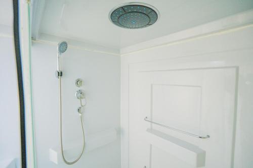 um chuveiro na casa de banho com uma cabeça de chuveiro em 伊豆Cocoグランピングリゾート em Ito