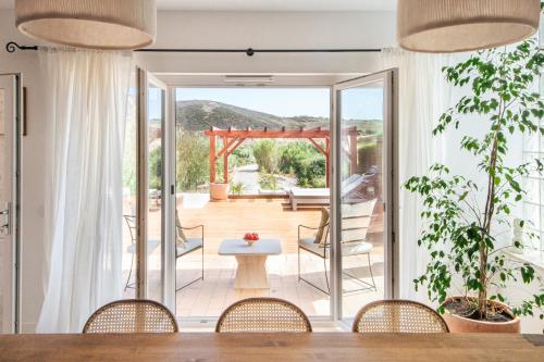 a dining room with a view of a patio at Casa da Almargens in Bordeira