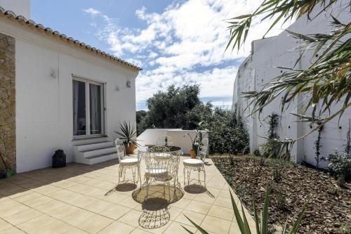 a patio with a table and chairs on a courtyard at Casa da Almargens in Bordeira