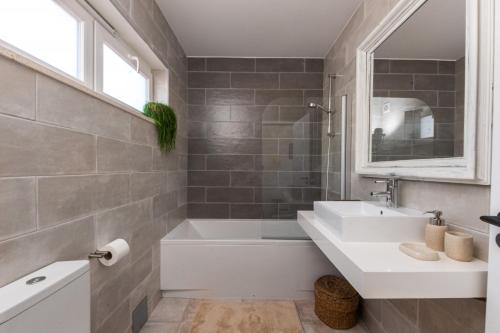 a bathroom with a sink and a tub and a mirror at Casa da Almargens in Bordeira