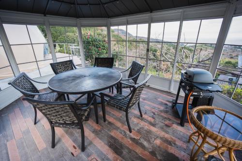 a screened in porch with a table and chairs and a grill at 伊豆Cocoグランピングリゾート in Ito
