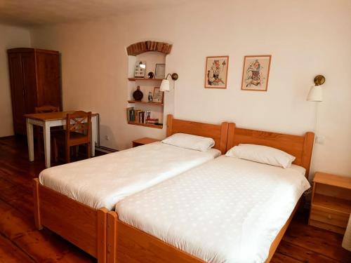 a bedroom with two twin beds and a table at Heltau Apartments in Cisnădie