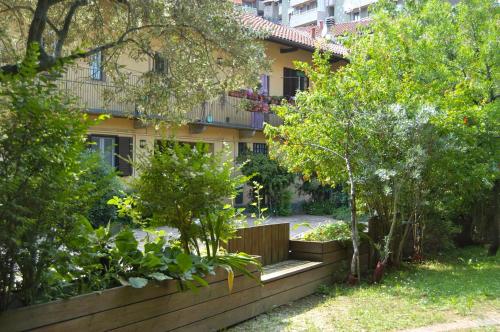 a garden in front of a building with trees at Corte Della Filanda Eco-design, Sesto San Giovanni in Sesto San Giovanni